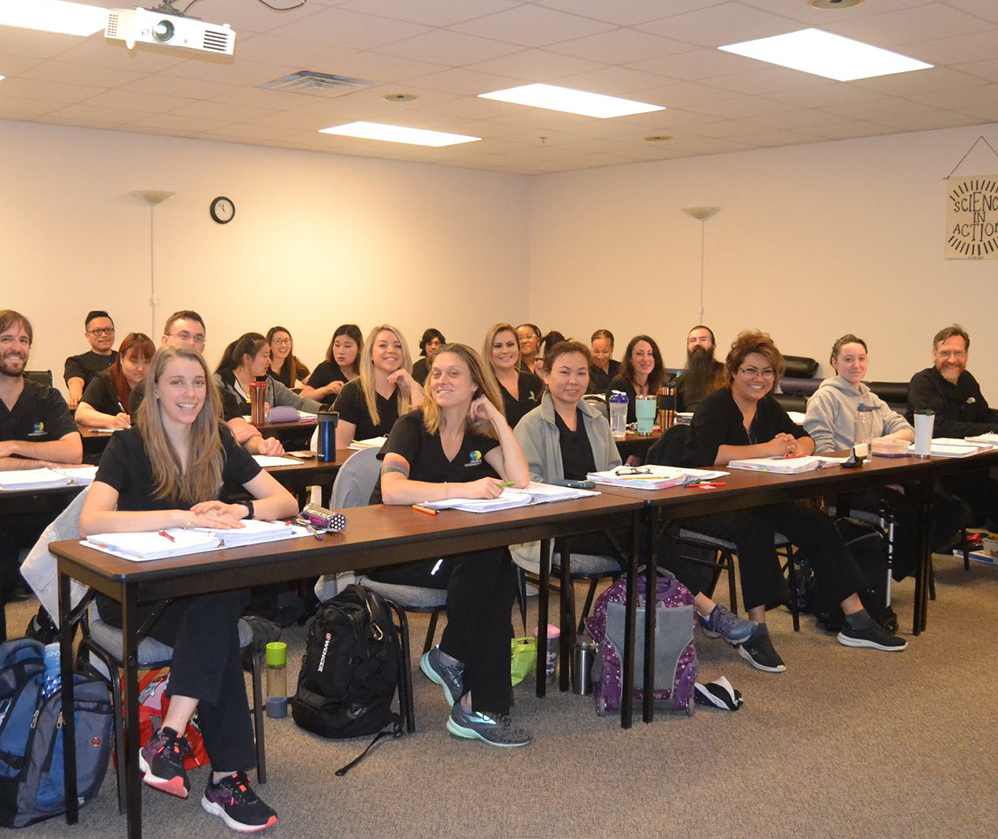 A classroom of students smiling at the camera.