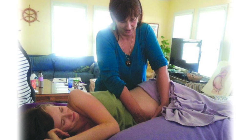 A massage therapist giving a massage to a pregnant woman.